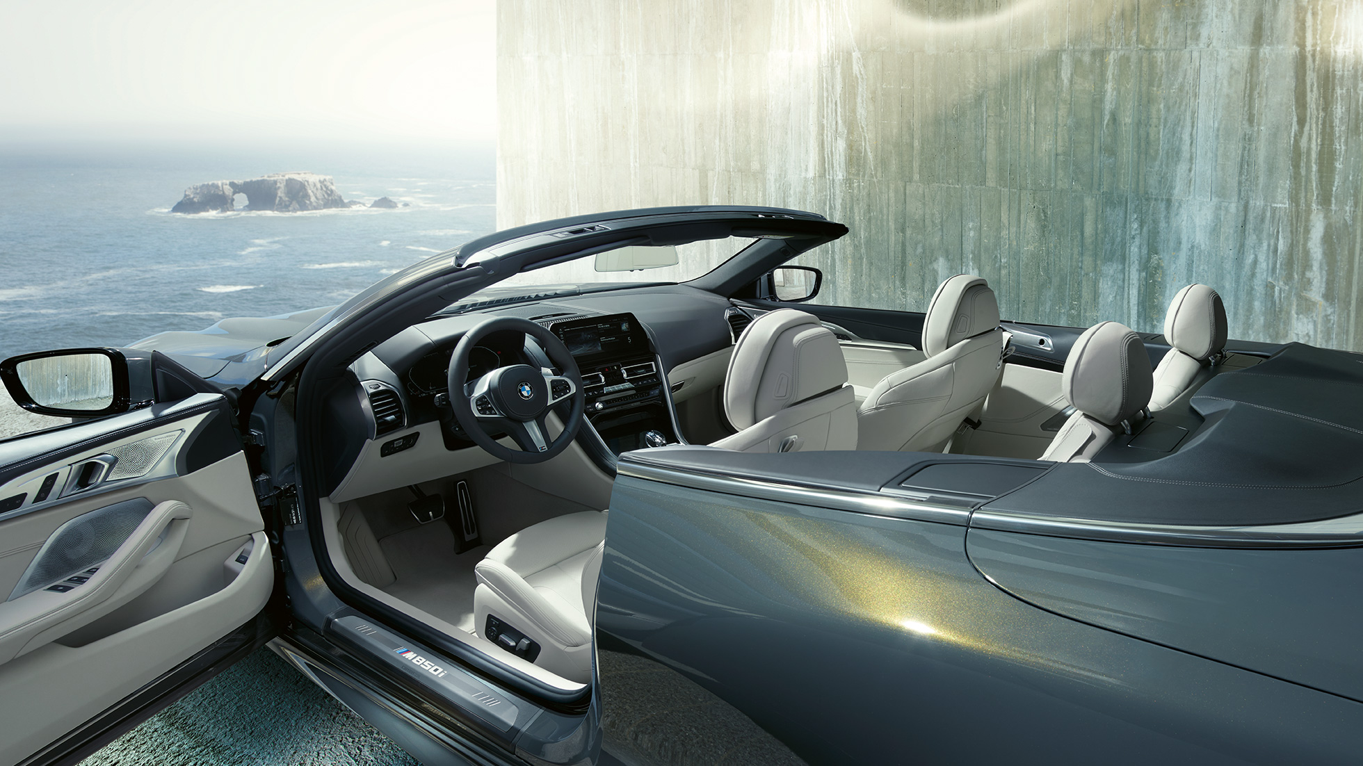 Interiorul BMW M850i xDrive Cabriolet. BMW M850i xDrive Cabriolet în Gri Dravit metalizat cu soft-top-ul deschis şi interiorul cu volan M îmbrăcat în piele şi ornamente din piele Merino în Alb Ivory de la BMW Individual.