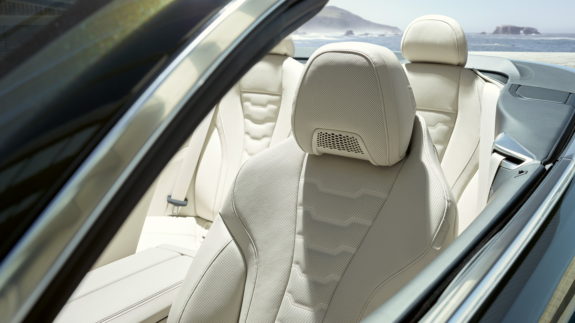 BMW M850i xDrive Cabriolet cu scaune multifuncţionale pentru conducătorul auto şi pasagerul faţă. BMW M850i xDrive Cabriolet în Gri Dravit metalizat cu soft-top-ul deschis şi interiorul cu scaune multifuncţionale cu ornamente din piele Merino în Alb Ivory de la BMW Individual.
