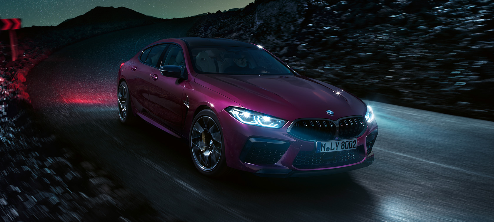 Imagine cu trei sferturi din partea frontală a BMW M8 Competition Gran Coupé Imagine cu trei sferturi din partea frontală a BMW M8 Competition Gran Coupé, F93, 2020, în Ametrin metalizat de la BMW Individual, rulând pe timp de noapte