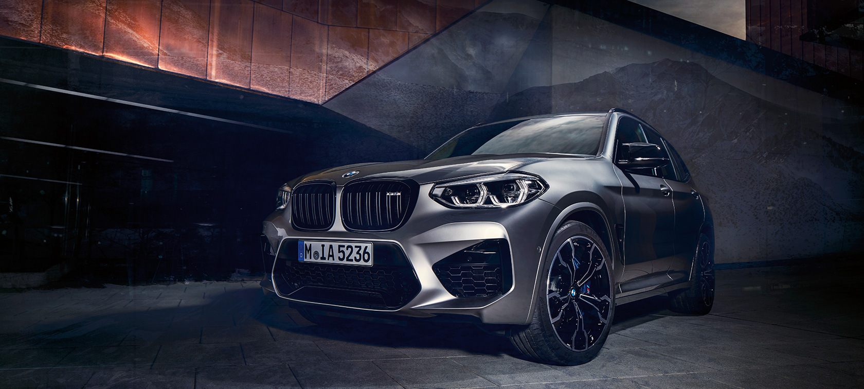 Imagine cu trei sferturi din partea frontală exterioară a BMW X3 M Competition în Gri Donington metalizat.