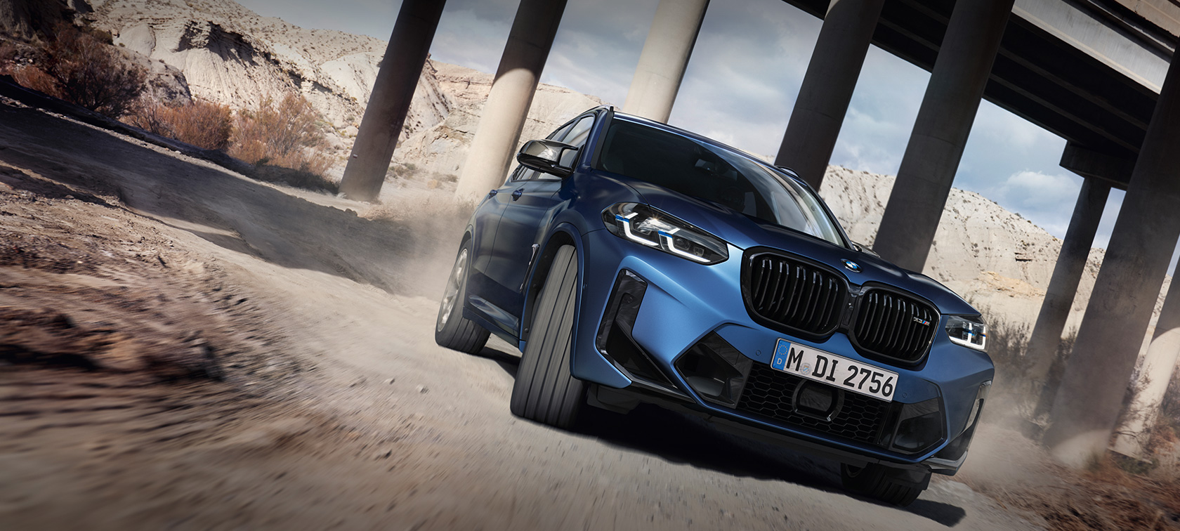 Imagine cu trei sferturi din partea frontală a unui BMW X3 M Competition F97 LCI 2021 în Albastru Frozen Marina Bay, în mers