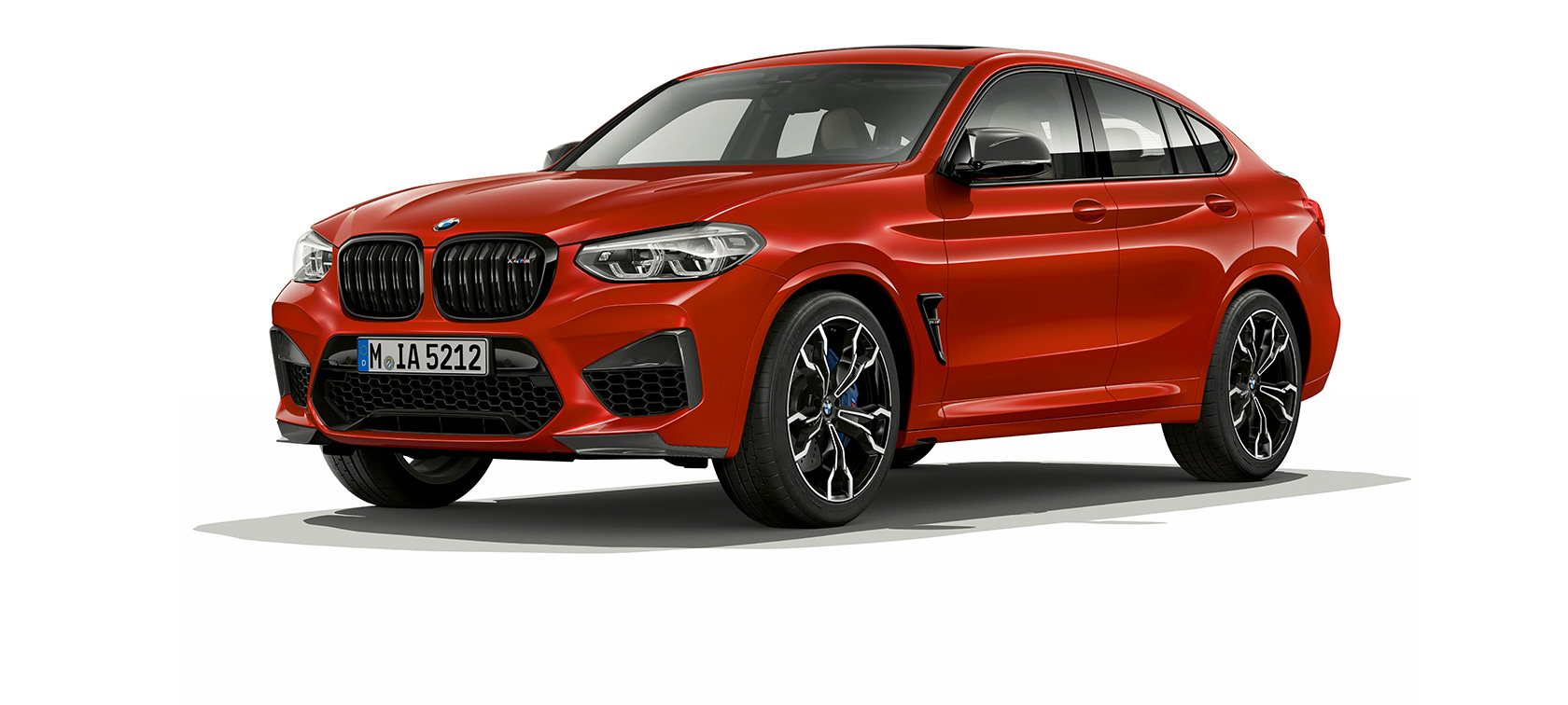 Imagine cu trei sferturi din partea laterală a BMW X4 M Competition. Imagine cu trei sferturi din partea laterală exterioară a BMW X4 M Competition în Roşu Toronto metalizat.