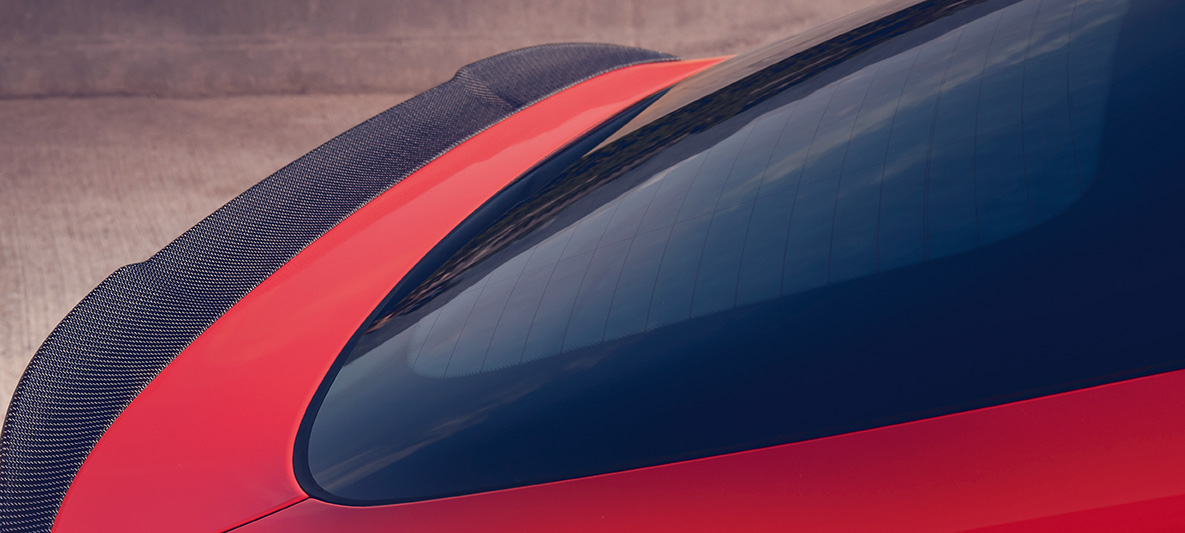 BMW X4 M Competition, cu spoiler M din carbon în partea spate. Imagine cu exteriorul BMW X4 M Competition în Roşu Toronto metalizat, cu pachet M din carbon pentru exterior şi spoiler M din carbon în partea spate.