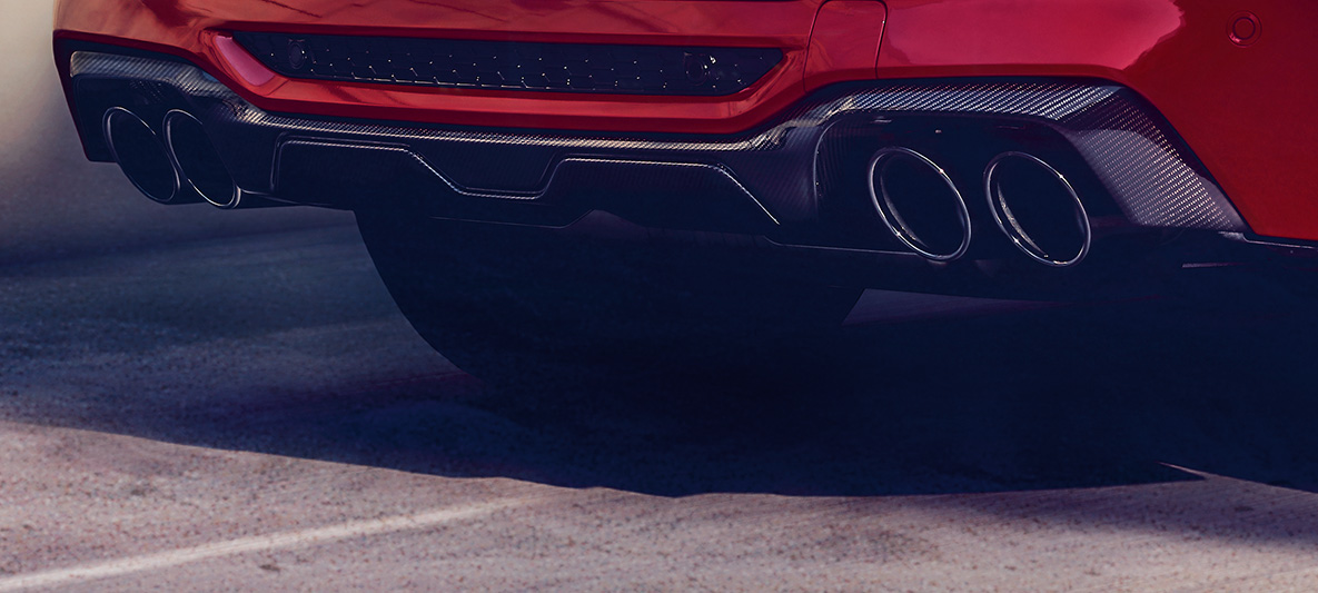 BMW X4 M Competition, cu difuzor aerodinamic din carbon în partea spate. Imagine cu exteriorul BMW X4 M Competition în Roşu Toronto metalizat, cu pachet M din carbon pentru exterior şi difuzor aerodinamic din carbon în partea spate.
