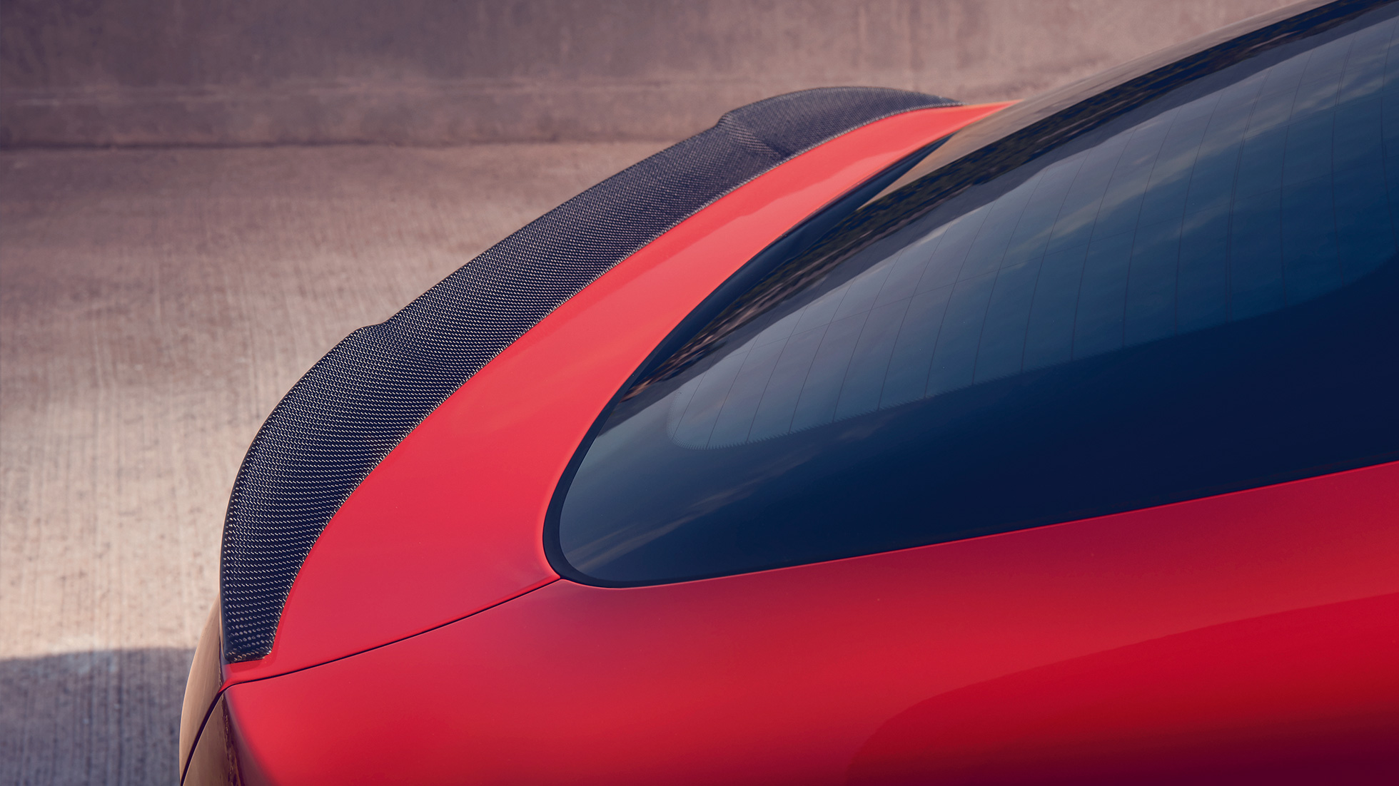 BMW X4 M Competition cu spoiler M din carbon în partea spate. Imagine cu exteriorul BMW X4 M Competition în Roşu Toronto metalizat cu pachet M din carbon pentru exterior şi spoiler M din carbon în partea spate.