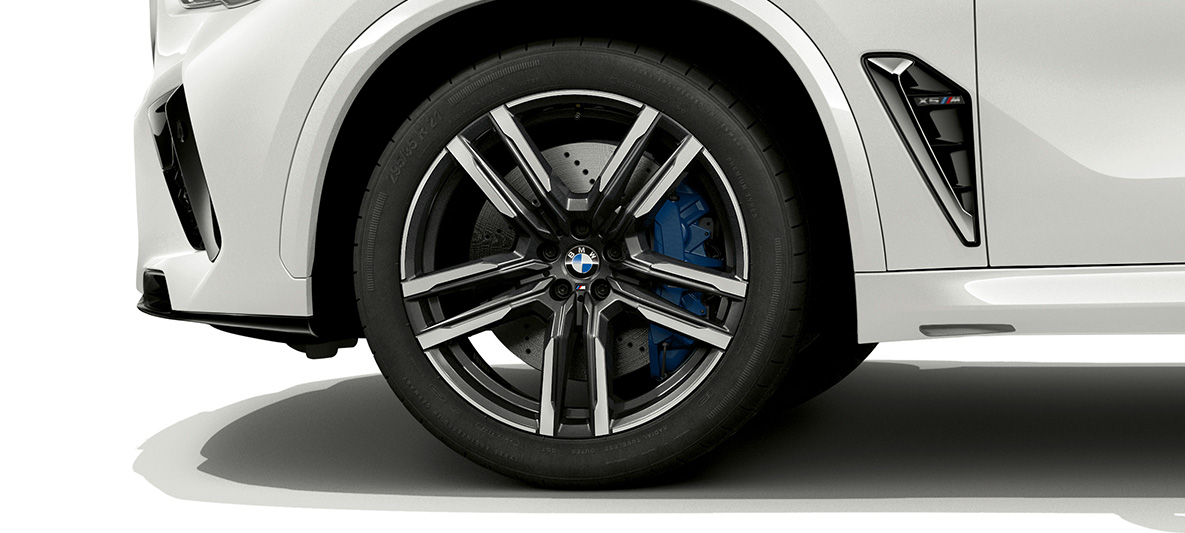 BMW X5 M cu jante M din aliaj uşor de 21”, în Gri Orbit bicolor Imagine în prim-plan cu BMW X5 M, F95, în Alb Mineral cu jante M din aliaj uşor de 21”, în Gri Orbit bicolor