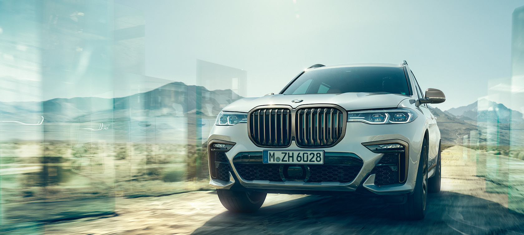 Imagine cu partea frontală a modelelor BMW X7 M50i şi BMW X7 M50d Imagine cu partea frontală a modelelor BMW X7 M, M50i şi M50d, în Alb Mineral, staţionând, G07