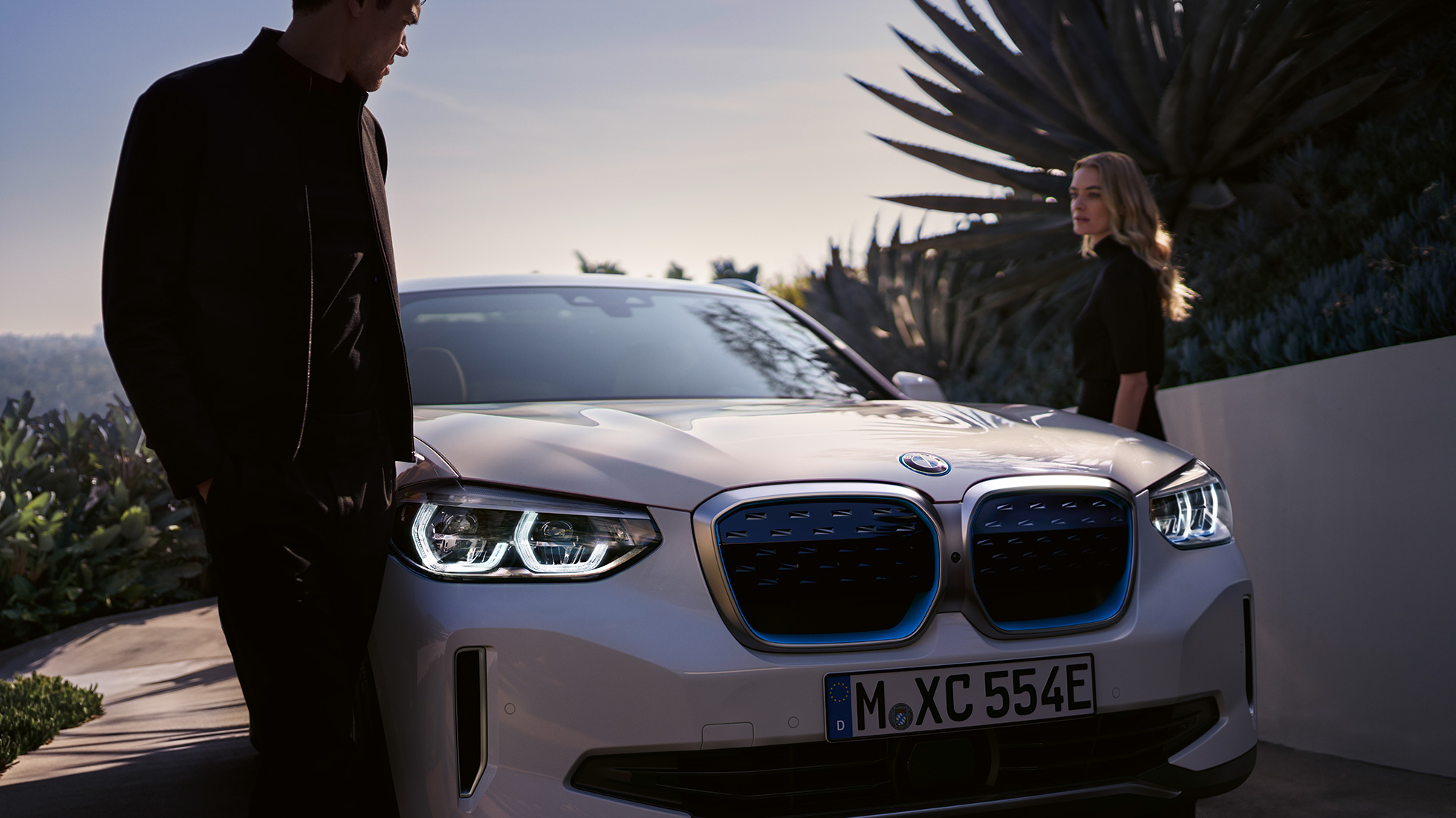 Imagine cu trei sferturi din partea frontală a BMW iX3, G08, cu grilă frontală BMW i Imagine cu trei sferturi din partea frontală a BMW iX3, G08, 2020, în Alb Mineral metalizat, cu grilă frontală BMW i