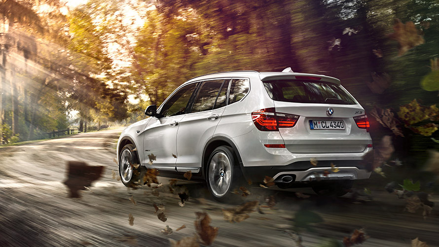 Imagine cu trei sferturi din partea din spate a BMW X3 F25 din a doua generaţie în mers pe stradă Imagine cu trei sferturi din partea din spate a BMW Seria X BMW X3 F25 din a doua generaţie în mers pe stradă