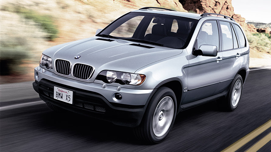 Imagine cu trei sferturi din partea frontală a BMW X5 E53 din prima generaţie în mers pe stradă Imagine cu trei sferturi din partea frontală a BMW Seria X BMW X5 E53 din prima generaţie în mers pe stradă