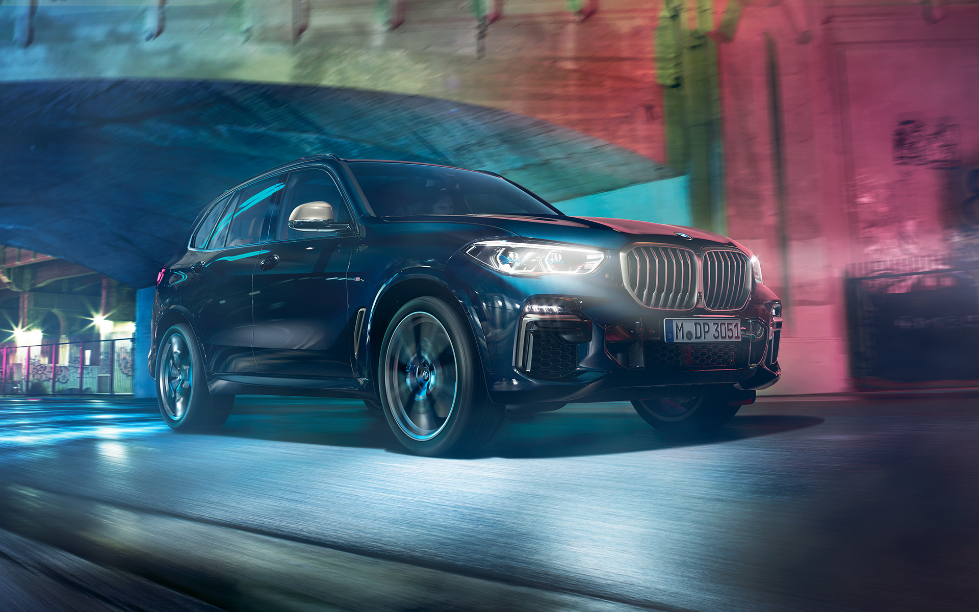 BMW X5 M50d în acţiune Imagine cu BMW X5 M50d rulând noaptea într-un peisaj urban