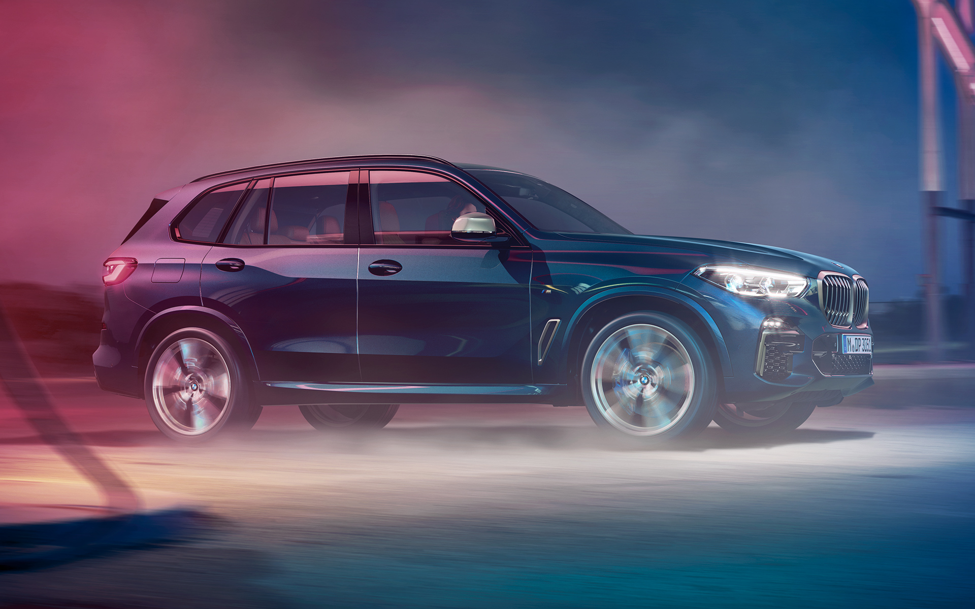 BMW X5 M50d în mişcare Imagine cu BMW X5 M50d rulând noaptea într-un peisaj urban