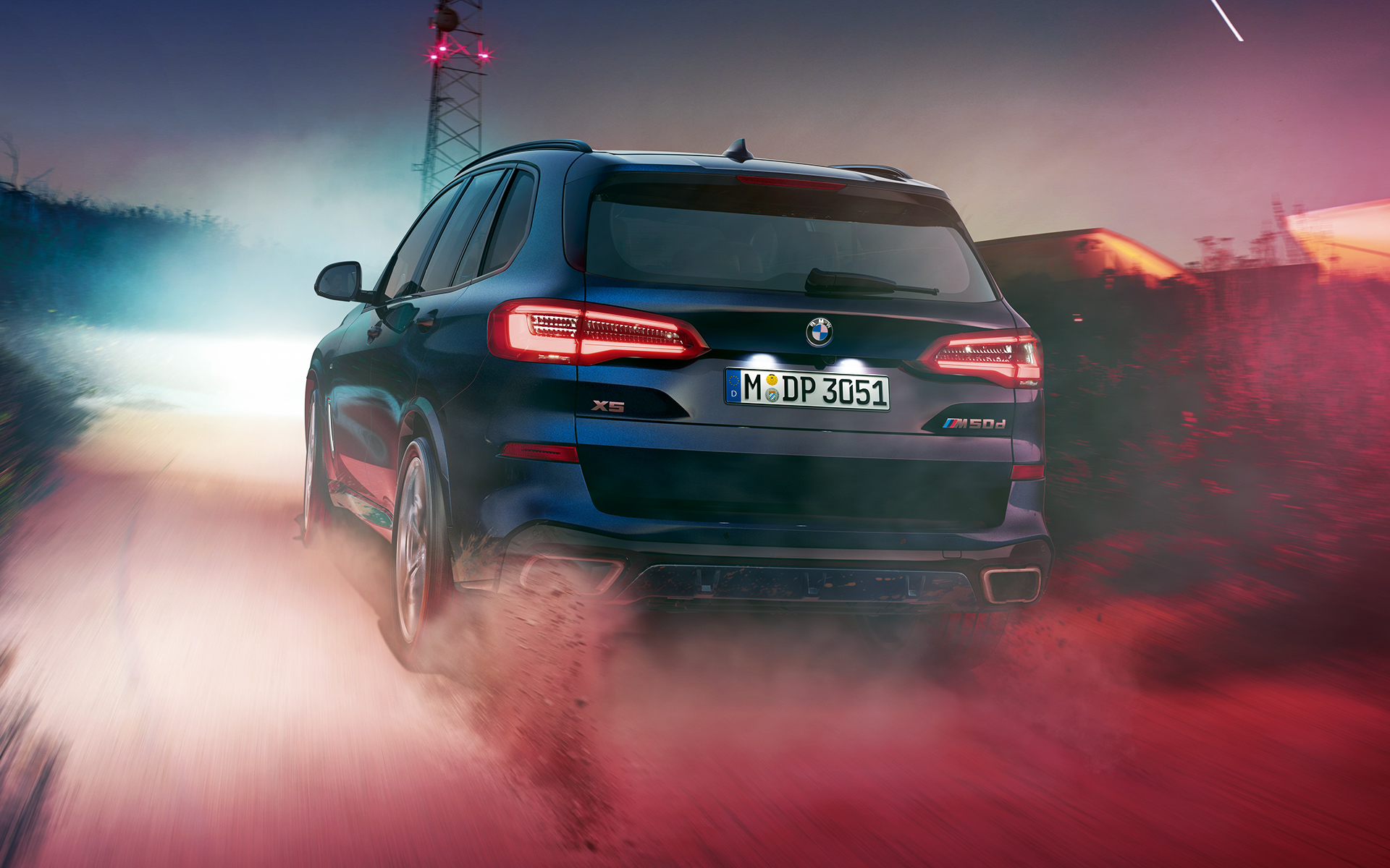 Partea spate a BMW X5 M50d Partea spate a BMW X5 M50d pe timp de noapte într-un peisaj urban