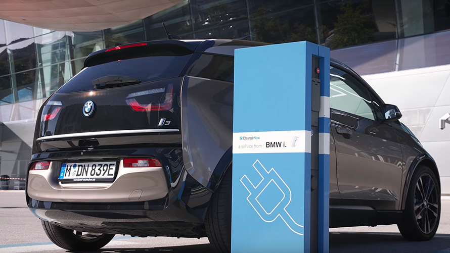 BMW i3 la o staţie de încărcare Imagine cu trei sferturi din partea din spate cu modelele BMW i3 la staţia de încărcare