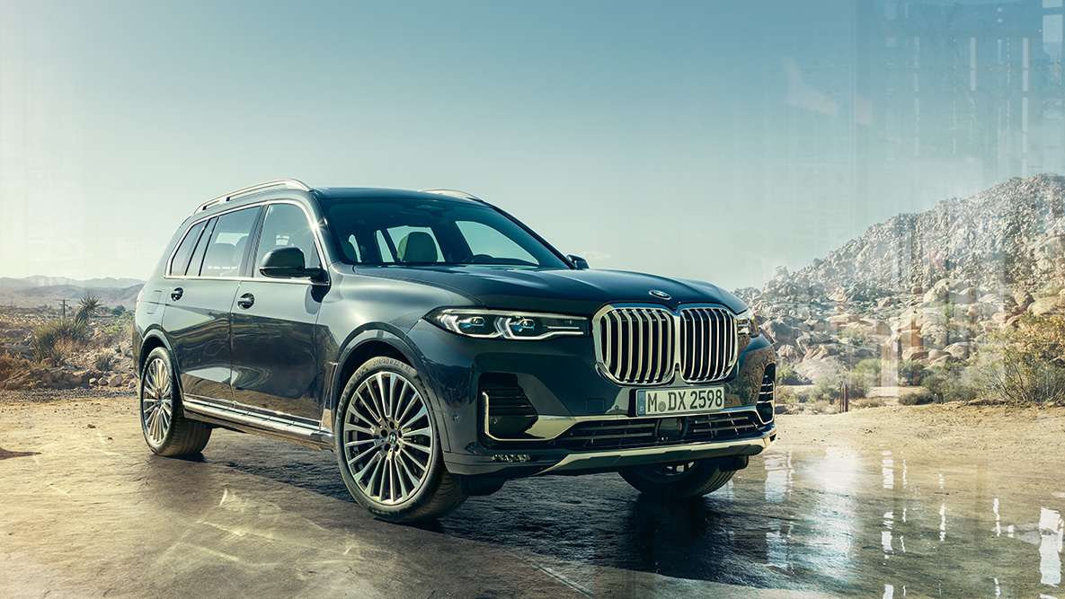 Imagine cu trei sferturi din partea frontală a exteriorului BMW X7 Exteriorul BMW X7: imagine cu trei sferturi din partea frontală în faţa unui fundal deşertic