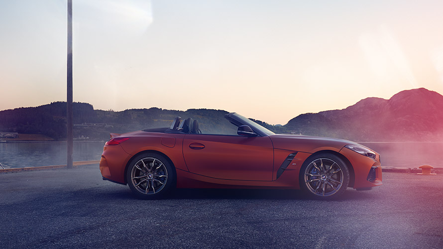 BMW Z4 „First Edition” portocaliu staţionând în viraj BMW Z4 „First Edition” portocaliu staţionând în viraj, în faţa unui peisaj montan