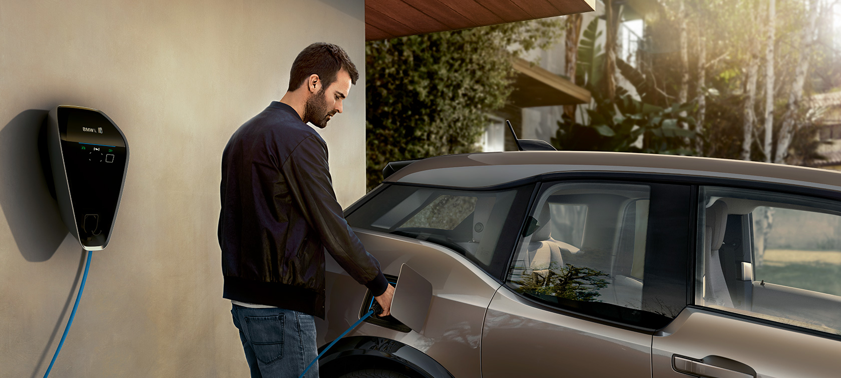 Un bărbat încărcând un BMW i3s la staţia de încărcare Imagine cu un bărbat încărcând un BMW i3s la staţia de încărcare