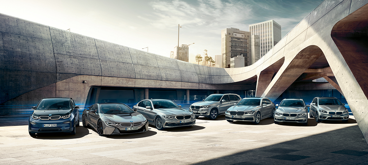 Modelele BMW electrice şi hibrid „plug-in” în faţa unor clădiri Imagine cu modelele BMW electrice şi plug-in hybrid în faţa unor clădiri