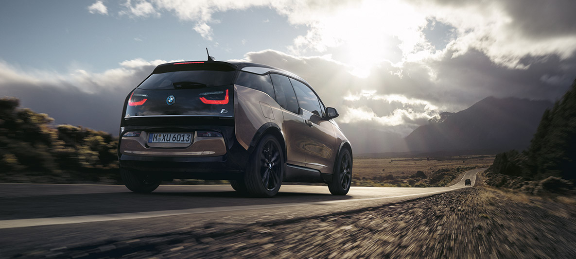 Un model BMW i3s cu un peisaj de munte pe fundal Exemplu privind autonomia BMW: imagine cu trei sferturi din partea spate a unui model BMW i3s cu un peisaj de munte pe fundal