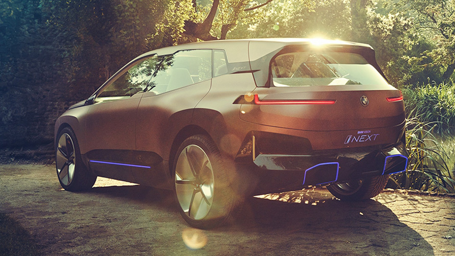 BMW Vision iNEXT în faţa unei păduri Imagine cu trei sferturi din partea frontală a BMW Vision iNEXT în faţa unei păduri