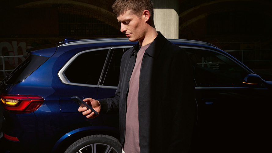 BMW Digital Key – instalează până la cinci utilizatori BMW Digital Key instalează până la cinci utilizatori bărbat cu smartphone în faţa unui BMW X5