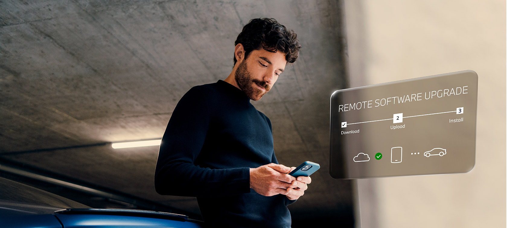 Bărbat în faţa unui automobil BMW uitându-se la smartphone-ul său Remote Software Upgrade Bărbat în faţa unui automobil BMW uitându-se la smartphone-ul său