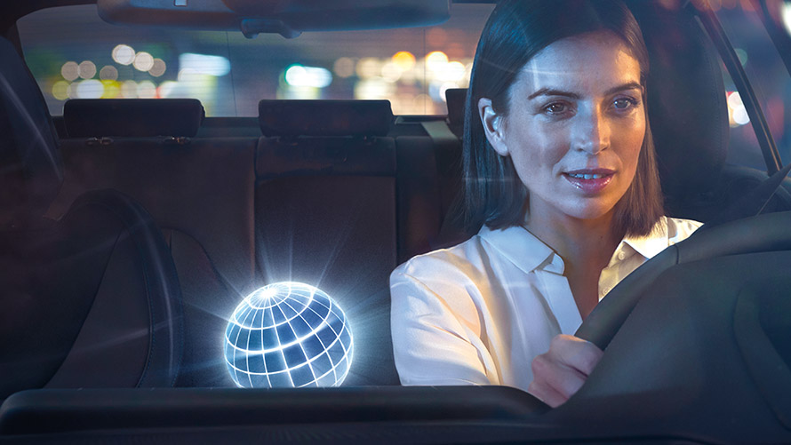 „BMW Intelligent Personal Assistant”: Interacţiune naturală O femeie conducând un automobil BMW într-un peisaj nocturn