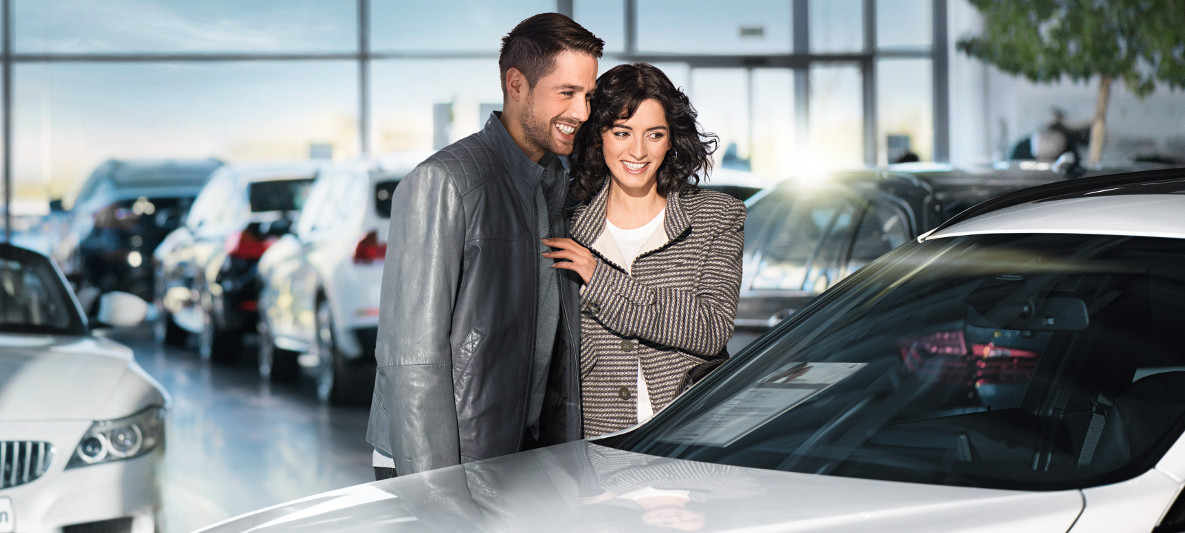 Imagine cu un bărbat şi o femeie privind un automobil BMW Imagine cu un bărbat şi o femeie privind un automobil BMW