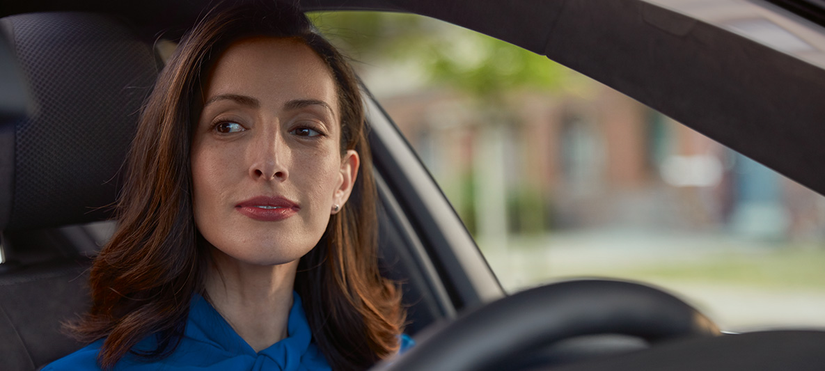 O femeie stând în automobilul său BMW, zâmbind O femeie stând în automobilul său BMW, zâmbind