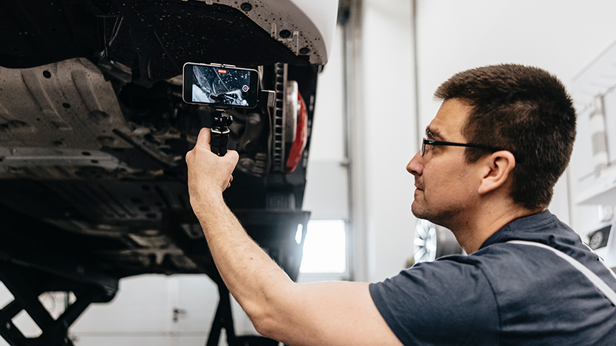 Mecanic dintr-un atelier BMW filmând frânele BMW. Mecanic dintr-un atelier BMW filmând frânele BMW.