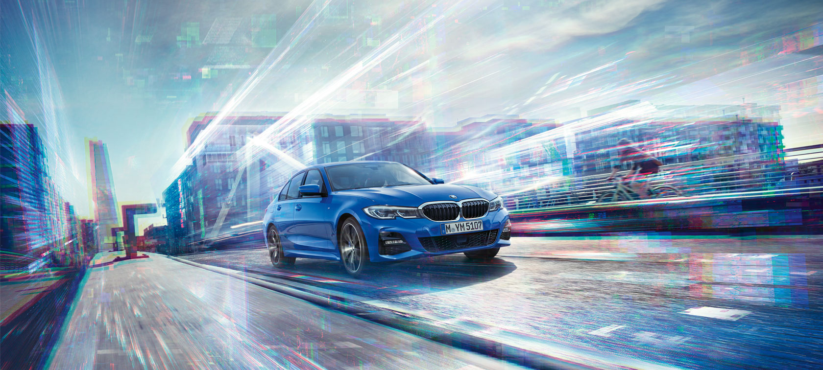 Perspectivă din faţă a BMW Seria 3 Sedan. Imagine cu partea frontală a BMW Seria 3 Sedan, pe timpul zilei, în faţa unei clădiri din sticlă