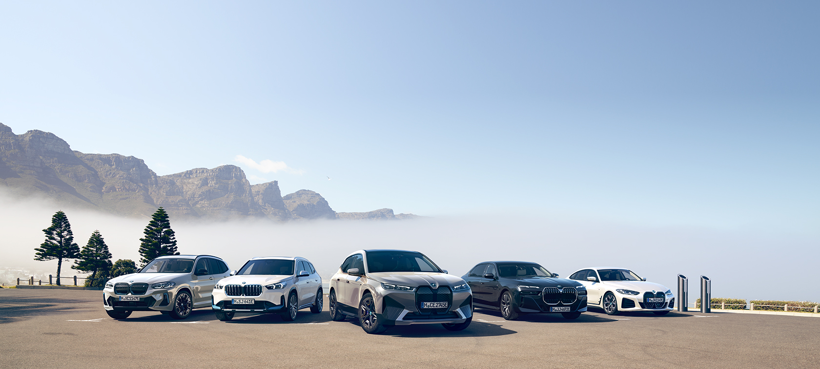 Imagine din partea frontală a unui BMW iX conectat la sistemul Wallbox de acasă Imagine din partea frontală a unui BMW iX conectat la sistemul Wallbox dintr-un garaj cu panouri din lemn